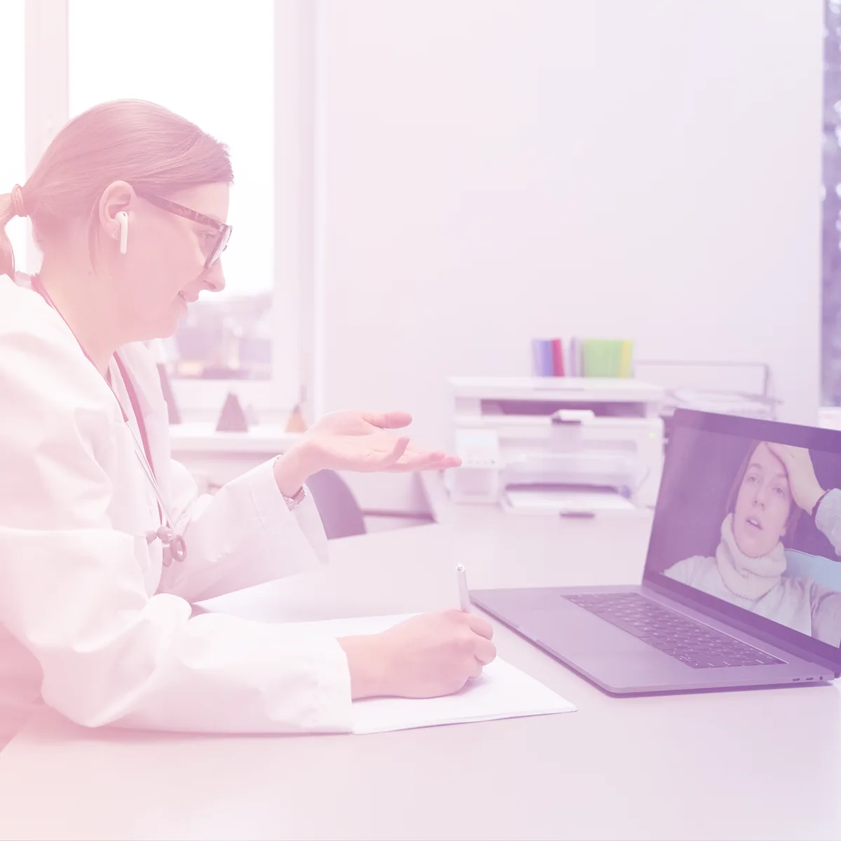 Une médecin en téléconsultation avec une patiente, visible sur l’écran de son ordinateur portable